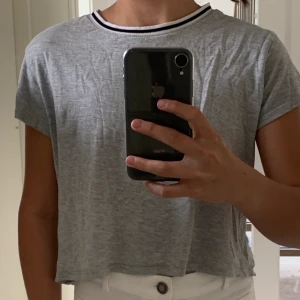 Grey t-shirt with black and white lining on the color  - You can try on before buying