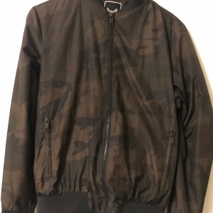 Bomberjacka  - En militär mönstrad bomber jacka. I storlek S. Säljer för 50kr + frakt  prutning finns annars högst pris vinner. Kan annars mötas i Linköping, Mjölby eller Boxholm. Kan tvättas om det önskas.