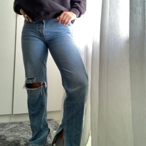 Snygga jeans med slits! - Ett par blåa jeans, lite låg midjade, med slits och ett hål på knät! Byxorna köpta för ett tag sen men har inte kunnat använda dem då dem sitte taight i midjan på mig, annars as coola jeans! Köparen betalar för frakt!⭐️💕👍🏼