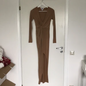 Beige/brun klänning från Rebecca Stella - Säljer min fina klänning från Rebecca Stella. Den är i storlek xs och använd 1 gång. Den har nu blivit för tajt på den övre delen vilket ör anledningen till varför jag säljer den. Den är special sydd i längden eftersom den var för lång för mig, jag är 165cm. På andra bilden ser det ut som sömnen lossnat lite men det har den inte och är intakt. Nypris är 400/500kr. Bara o skriva om ni har eventuella frågor!