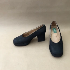 Sjukt snygga retro klackar i svart - Sjukt sjukt sjukt snygga klackar i mocka. Färg är svart eller mörkt marinblåa. Tjock, tuff klack. Strl 38 med 7-8cm klack. Inköpta någon gång på 90-talet men de är knappt använda.