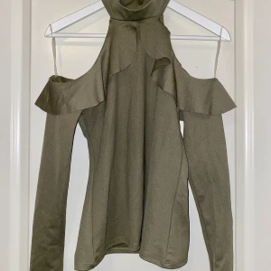 MilitärGrön blus - Perfekt Vardaglig plus med en polokrage och lite volanger. Storlek xs/s