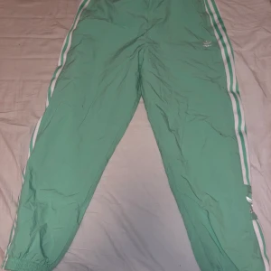 Adidas trackpants - Super fina Adidas byxor i sparsamt använt skick. Strl 42 men är supersnygga oversized😍 säljer de då de tyvärr blivit för små för mig🙈 superfin mintgrön färg❤️ 300 kronor ink frakt