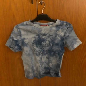  - Snygg blå topp. Aldrig använd. Tryck på bröstet. 