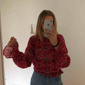  - En härlig röd blus i chiffong från Gina Tricot med ett blått/vitt/svart mönster. Köptes för något år sedan och ej blivit använd så mycket så därför säljer jag den.   Betalning via Swish och köparen står för frakten, kan mötas nära sölvesborg/bromölla!