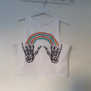 Cool croptop - Vit croptop m regnbåge o skelett. Materialet är stretchigt o känns typ lite som en baddräkt? 40kr + frakt (22kr)