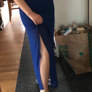 Maxikjol strl 34 - Mörkblå kjol från H&M i strl 34, men passar mig strl 36/38. slits på båda sidorna och två lager. Ett tjockt lager, går till mitten av låren + ett genomskinligt lager, går ner till anklarna. Kan mötas upp i Stockholm, annars frakt 40 kr :)