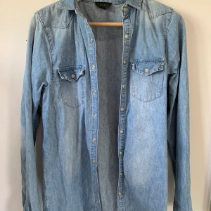 Jeansskjorta från Topshop i storlek 34 - Lite längre jeansskjorta från Topshop. Skriv för fler bilder! 