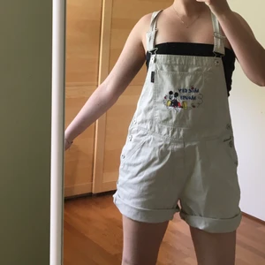 Beige Disney mickey mouse overalls - Overall med broderad mickey på. Märket är Disney, gjorda av bomull. Strlk M, men passar som oversized på mindre storlekar (jag är strlk S). 