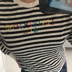 Levis longsleeve - En snygg randig longsleeve med ett färgglatt broderat tryck fram till! Knappt använd då det inte är min stil! Du står för frakten, jag ansvarar inte för postens slarv!