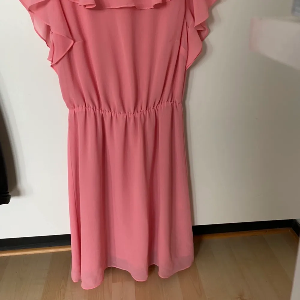 Superfin rosa klänning med volanger från H&M strl 36. I myclet fint skick. Kan fraktas om köparen betalar frakten. Hund finns i hemmet!. Klänningar.