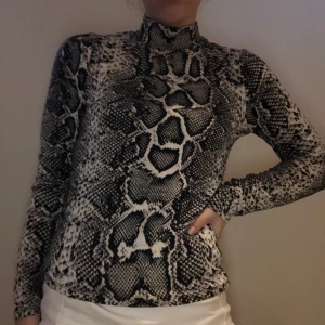 polotröja med snakeprint - EJ TILLGÄNGLIG JUST NU Polotröja från Gina Tricot med snakeprint i storlek M, mjukt och EJ skönt material. Sparsamt använd, ser och känns som ny. Köparen står för frakt, standardfrakt 63 kr med postnord. Betalning sker via swish. Inga returer. Skickas 1-2 dagar efter köp. 