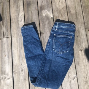 Calvin Klein jeans - Säljer ett par Calvin Klein jeans i mycket bra skick. Jag är 171/172 cm lång och frakten är + 66kr. Modellen heter Skinny High Rise och är i storlek W26 L32. Kontakta vid intresse, ungefär en XS/S