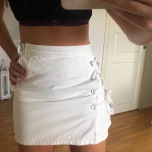 Vit kjol med snörning - Säljer denna då den är för liten för mig plus att som ni ser på bild 2 så har den man drar upp dragkedjan med lossnat :(. Orkar inte laga den men det är enkelt att bara sätta dit en sådan själv. 