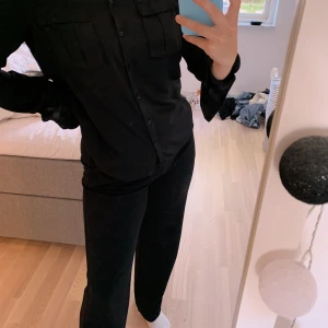 Svart satin skjorta - Svart satin skjorta från NA-KD i fint skick. Använd några enstaka gånger. På båda armarna är tyget lite vikt men det är inget som syns när man har den på sig (se bild). Strl XS  50 kr + 22 kr frakt 