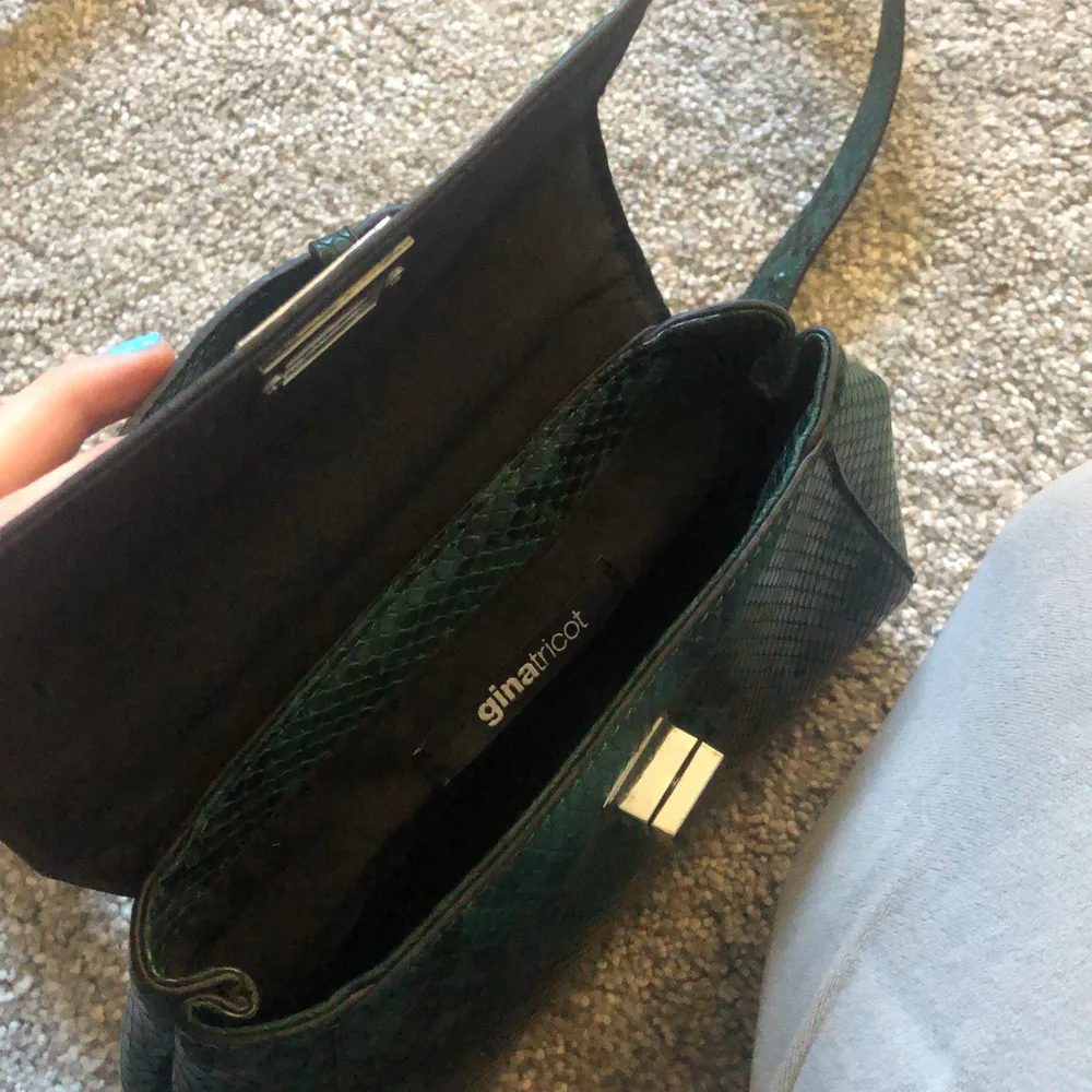 Säljer min gröna väska från ginatricot, väskan är i bra skick och är bara använd några gånger. Väskan har ett kort handtag och ett längre band. Silver spenen. . Accessoarer.