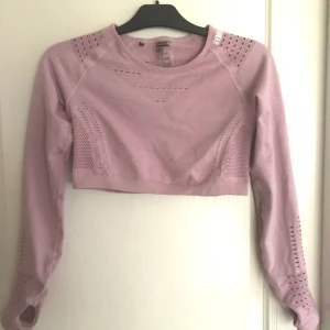 Gymshark crop top - Crop top från märket Gymshark i rosa färg. Storlek M. Tight passform och har hål för tummar. Pris kan diskuteras :) 
