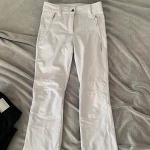 Vita täckbyxor  - Vita raka täckbyxor som är ganska tight runt låten upp till midjan. 