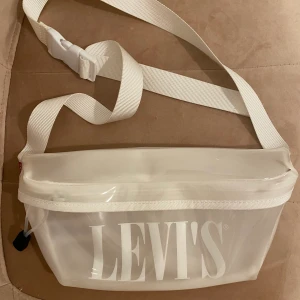 Levis väska - Helt oanvänd crossbody bag från Levis super fin halvt genomskinlig, kommer inte till användning. Köpt för 300kr oanvänd därav priset. Bara att skriva för fler frågor/bilder. 