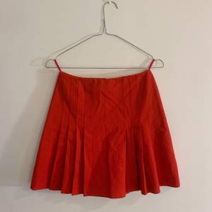 Retro, röd plisserad kjol. Bedömer den som en XS. 