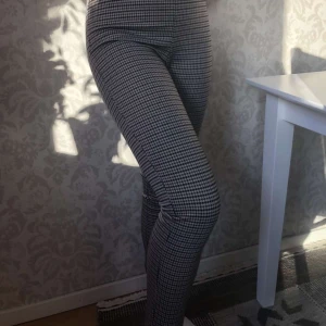 Rutiga byxor strl S - Stretchiga, highwaisted byxor i dogtooth-liknande mönster från hm. Svårt att få med färgen bra men den syns bäst på sista bilden, de är åt det brun-beiga hållet. Använda ett fåtal gånger men i superskick, inga tecken på användning! De har resår i midjan och innerbenslängden är ca 69 cm. Köparen står för frakt🍂