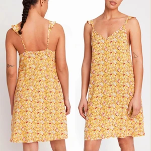 Gul blommig klänning Lindex XS - Färg: gulmönstrad.  Strl: XS.  Perfekt present -Helt Ny!  Från Lindex.  Mjukt med blommönster, v-ringning och axelband med volang. OBS. Lappar kvar!! Betalning via swish. Frakt tillkommer.