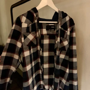 Flanellskjorta med luva  - Mörkblå och vit flanellskjorta med luva i storlek L. Enligt mig skulle jag säga att den är lite mindre. Typ storlek M. Skriv för fler bilder:) 