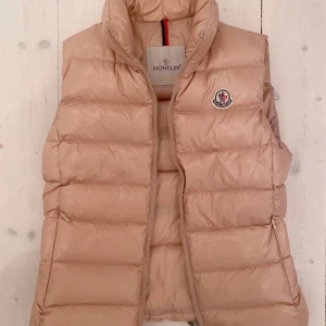 Moncler väst - Säljer min snygga rosa moncler väst. Jag är 1,77cm lång och tyvärr är den för liten för mig. Använt den bara några få gånger, den är i superbra skick. Köparen står för frakt!