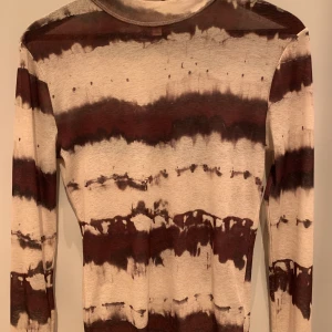 Brunvit melerad tröja  - En superfin, tunn och mjuk tröja. Lite genomskinlig. Sitter tajt men är väldigt töjbar så kan fungera på många olika kroppstyper!