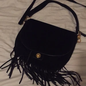  - Oanvänd svart väska med fransar. Jättefin men kommer aldrig till användning.

Fraktar men då står köparen för portot :) 