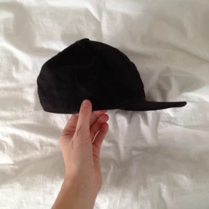 En ball svart keps, ganska stor - En ball svart keps, ganska stor