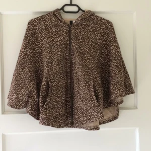  - Leopardmönstrad poncho med luva. Märkt "onesize".  Kan mötas upp i Uppsala, annars står köparen för frakten:)