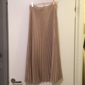  - Fin plisserad puderrosa kjol från Mango. Aldrig använd. Snygg till en svart polo eller vitt instoppat linne t.ex. 80 cm längd.