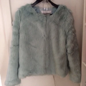  - Fuskpäls från Nelly. Mintgrön/blå. 