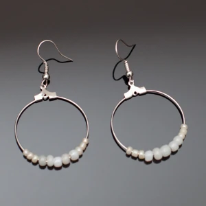  - Fina silverfärgade örhängen med vita pärlor i olika storlekar. Krokarna ska vara nickelfria enligt leverantör.  Fri frakt vid köp över 100:-.