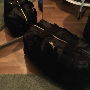  - Svart Puma väska med guldiga detaljer! Denna väska är i en perfekt storlek enligt mig eftersom att den är lite mindre än de vanliga träningsväskorna. Väldigt bra skick då den sällan kom till användning🥰köpt för 999kr  Pris kan diskuteras 