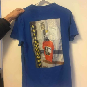  - Skitcool och unik blå T-shirt från Weekday! Med massa häftiga tryck på både fram och baksida!