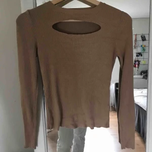  - En beige tröja med ett hål över bysten från Dilvin, aldrig använd. 