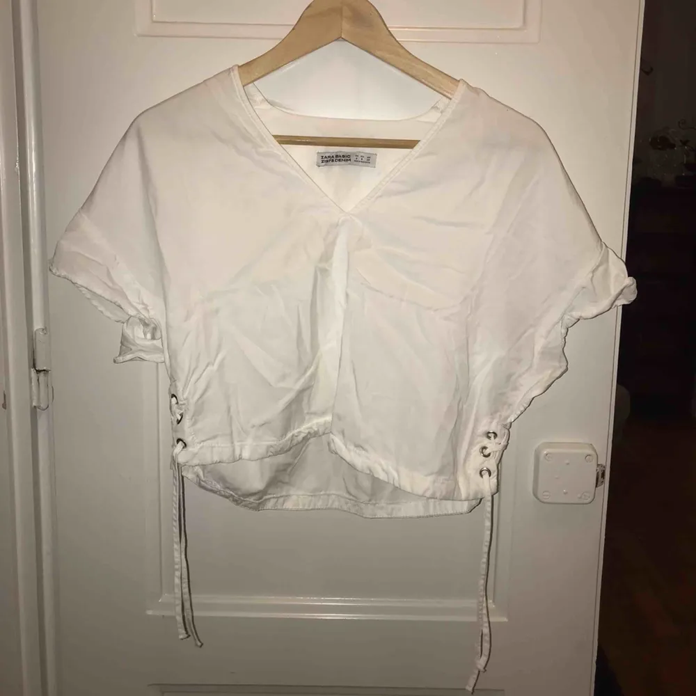 En ostruken vit tröja Zara. Volanger på ärmarna, samt knytning vid midjan. . T-shirts.
