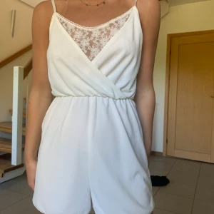 Vit jumpsuit  - Vit Jumpsuit med spets som är perfekt för sommaren! Öppen i ryggen och V-ringas. Kommer från H&M och är i storlek XS. Köparen står för frakt 😊