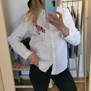 Vit skjorta med blommor - Använd en gång, bra kvalitet, har svaga märken på undersidan av ärmen som inte syns och säker går bort i tvätt. Står L men passar en S/M (jag är en S) 