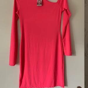 Neonfärgad klänning från Boohoo - Helt ny klänning,endast testad. Prislapp kvar. Färgen stämmer in med den som på hemsidan visar, blev konstigt med ljuset. 