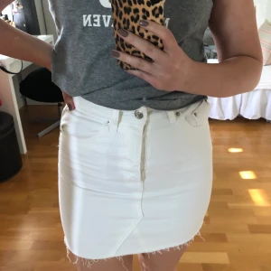 Vit jeanskjol - Vit jeanskjol från ginatricot, köpte förra sommaren men säljer den då den inte passar längre, bra skick. Fickor fram och bak, knappar som gylf. Kan mötas upp eller fraktas, köparen står för frakten. Köpt för 349kr. Frakten är inkluderad.