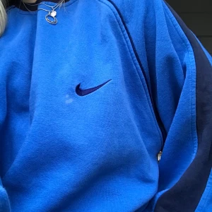 Nike sweatshirt - Säljer denna såå fina sweatshirt från Nike som tyvärr ej används så mycket längre. Har tråkigt nog en liten fläck vid loggan men den märks nästan inte. Väldigt oversized, på bilderna har jag vikt upp den. Buda gärna, avslutar budgivning imorgon kl 12.