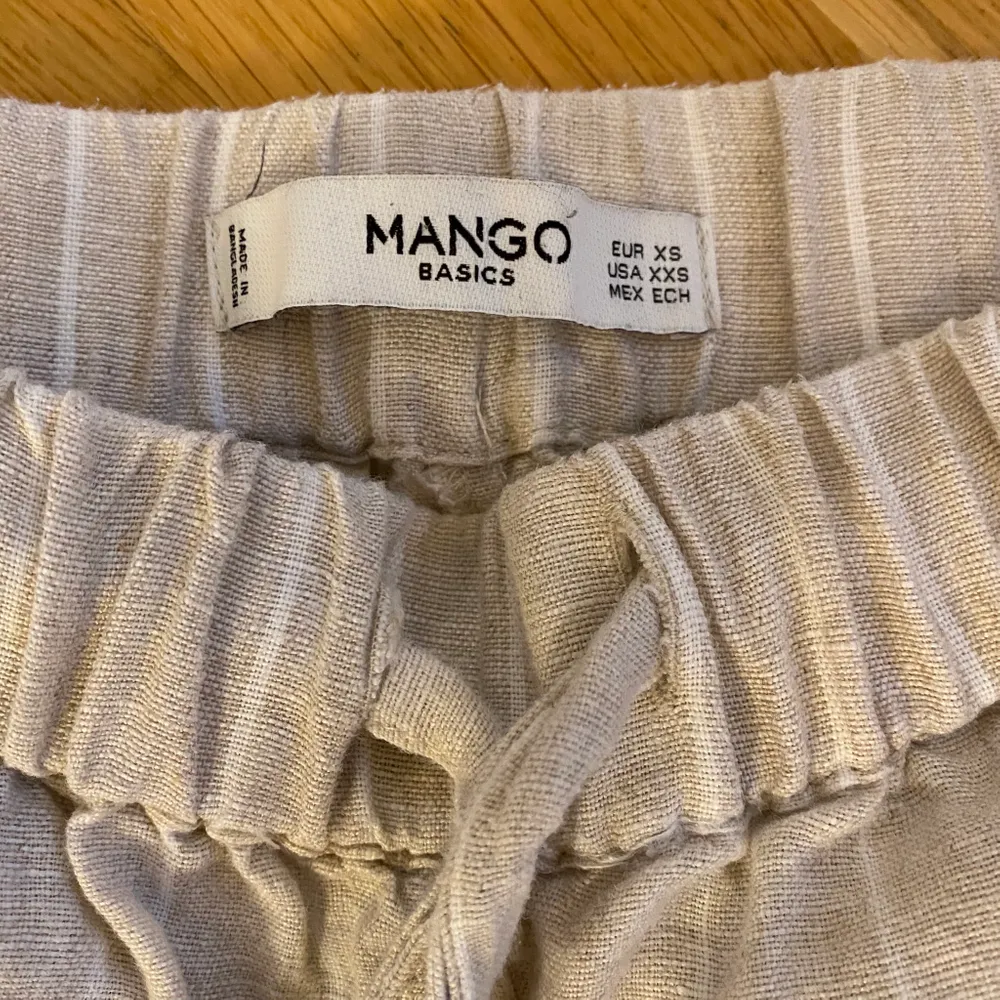 Säljer dessa beigea linne byxor med vita ränder från Mango. Bra kvalitet och så snygga till sommaren! Är 167 och brukar ha 34/36 i byxor och dessa sitter bra förutom att de är en aning för korta. Jeans & Byxor.