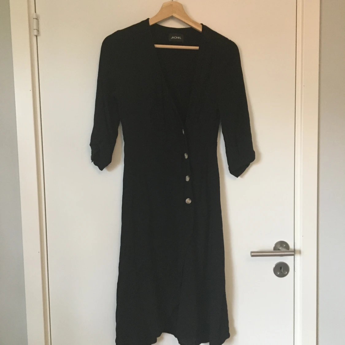 Svart klänning med omlottknäppning Monki