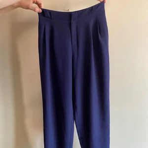 Kostymbyxor - Kostymbyxor i en lite mörkare blå färg. Sitter perfekt runt rumpan och blir sedan lösa, raka på benen. Finns fickor på sidorna och två fejk baktill. Tyvärr passar de inte mig längre men detta är ett riktigt bra köp! 