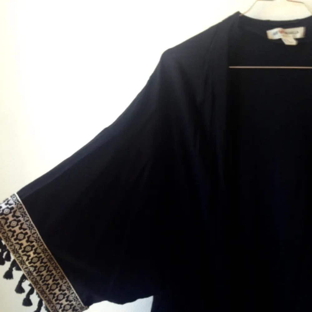 En svart kimono med vita detaljer. Vadlång. Tillhör Coachella-kollektionen från H&M. I mycket fint. . Tröjor & Koftor.