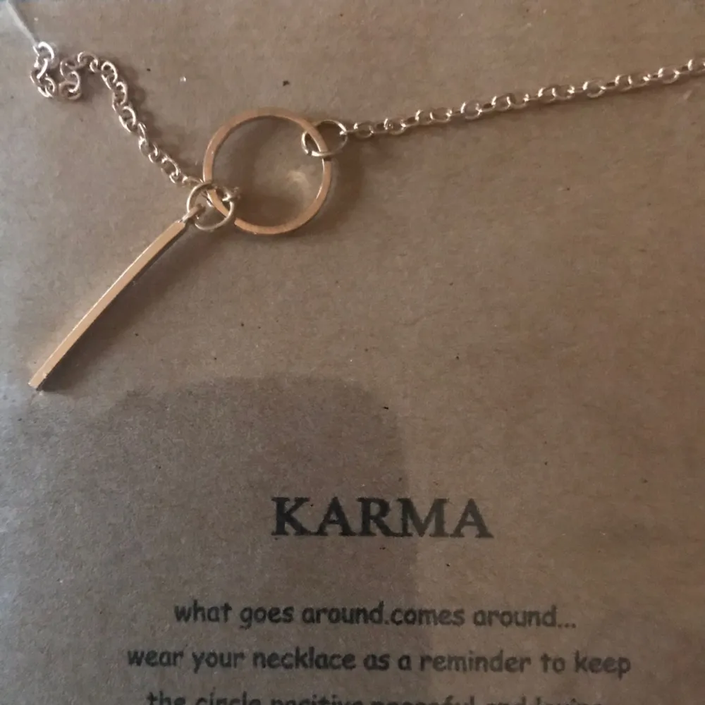 Guld pläterat halsband med symbol för karma. Text med råd medföljer. Accessoarer.