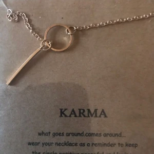  - Guld pläterat halsband med symbol för karma. Text med råd medföljer